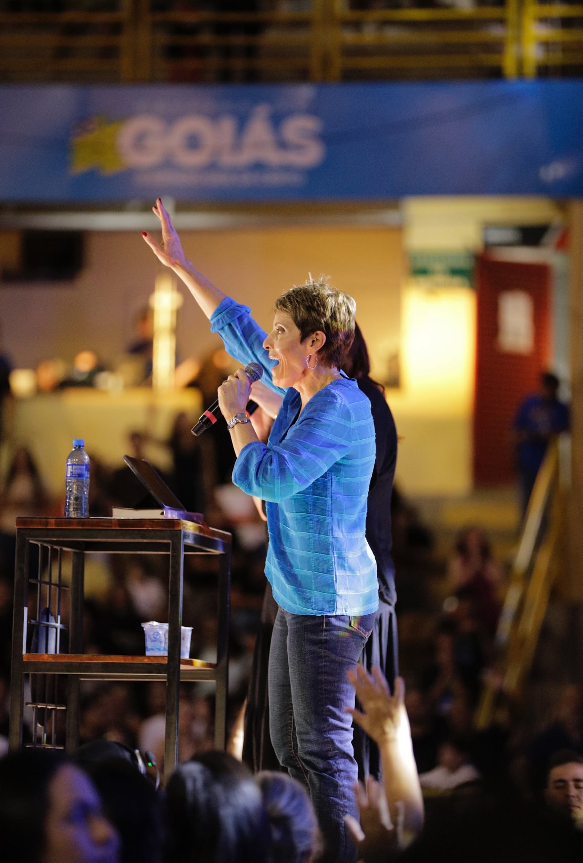 Joanne Moody speaking to a crowd with her hand raised