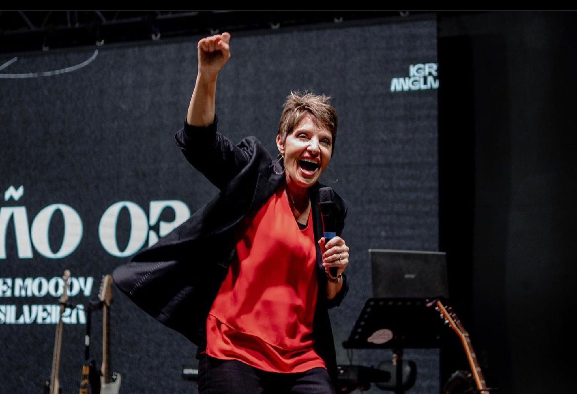 Rev. Joanne Moody, founder of Agape Freedom Fighters, ministering on stage with her fist raised