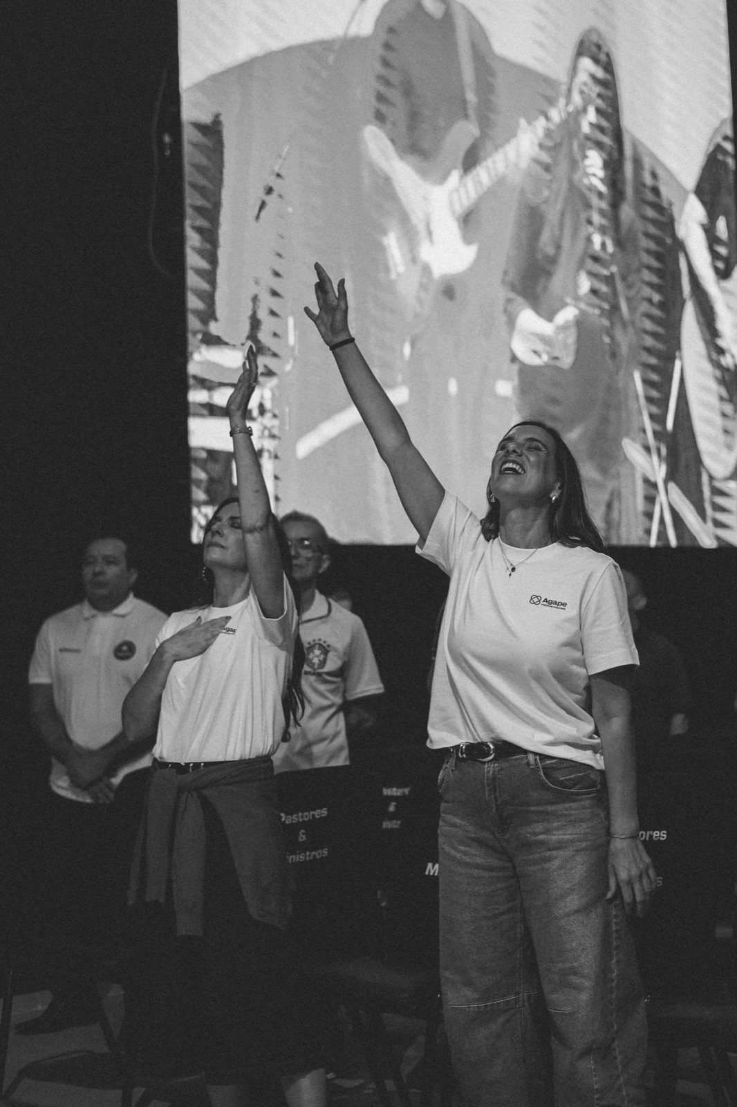 Two believers worshipping together on stage, in black and white