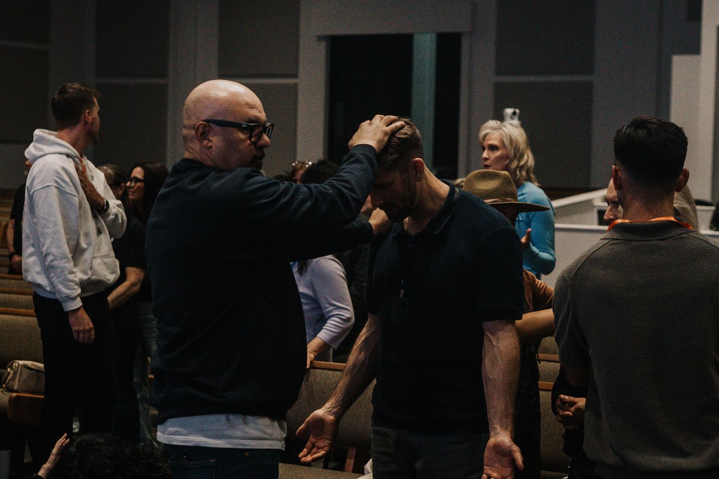A man praying with his hand on another man's head