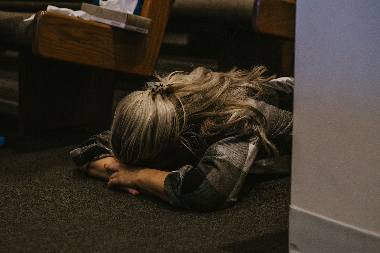 A woman lying face down in prayer between the pews
